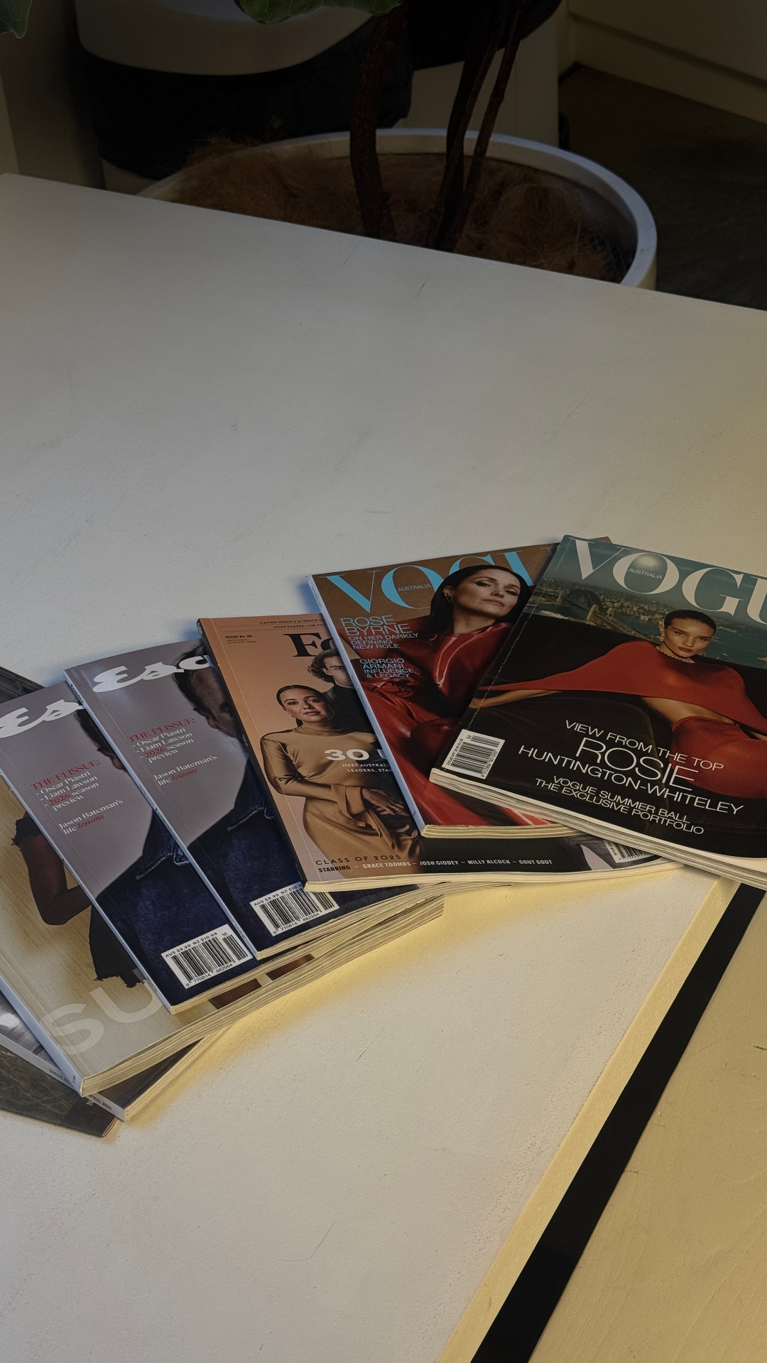 Stack of Vogue and Esquire magazines on a desk