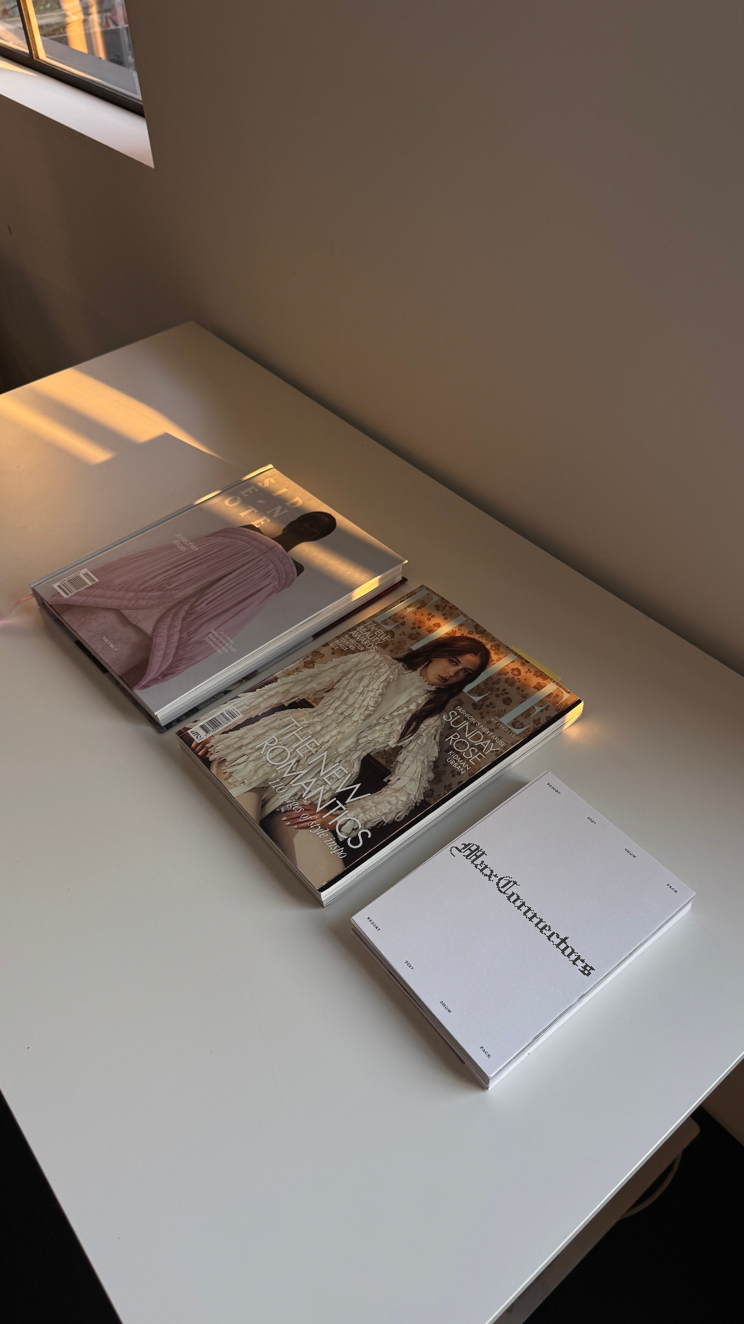 Magazines arranged on a sunlit desk