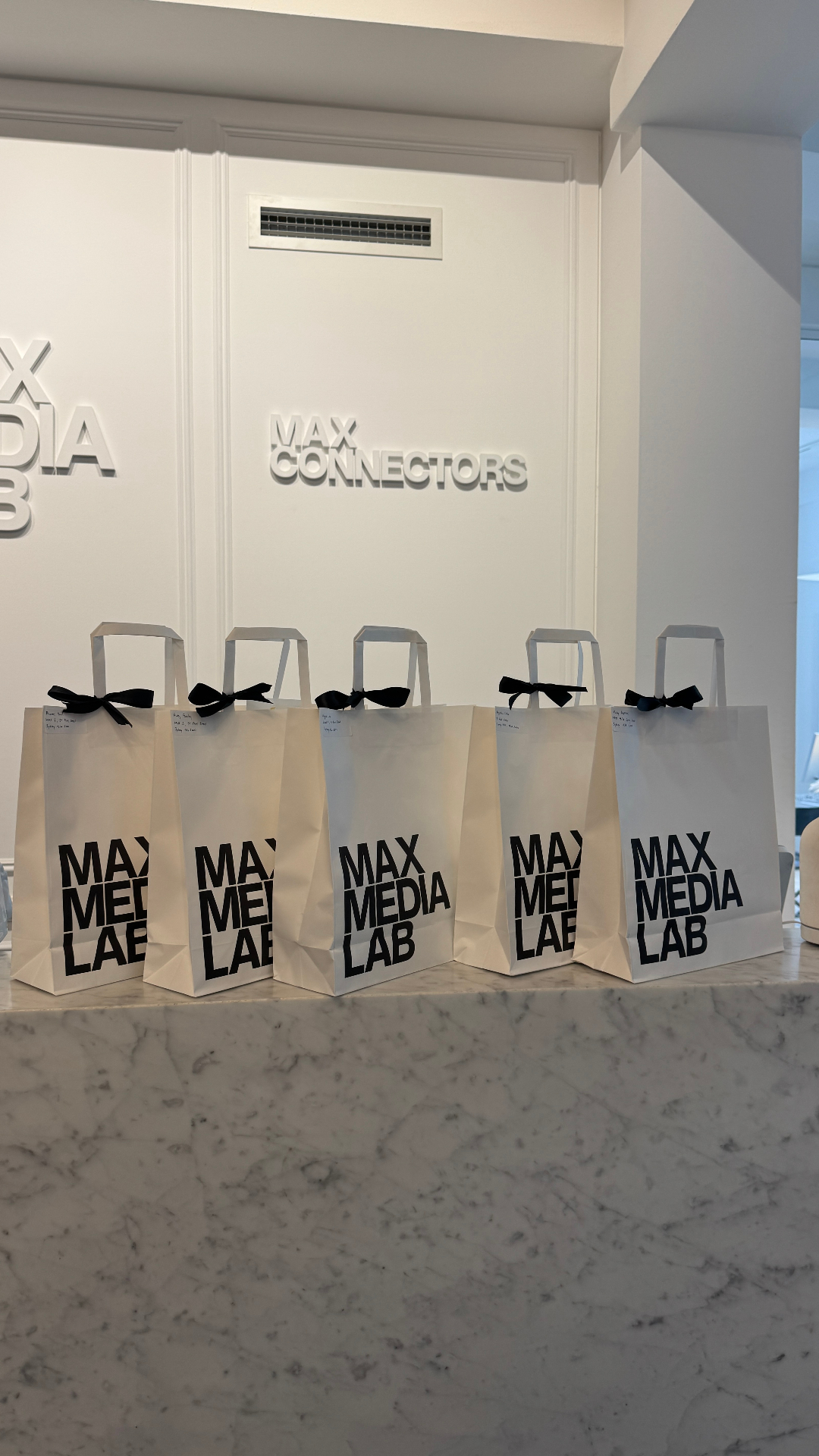 Max Media Lab gift bags lined up on marble
